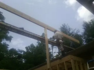 Carpenter setting a ridge beam over a new addition frame — Ice Dam Removal by Roofing Brothers in Corral