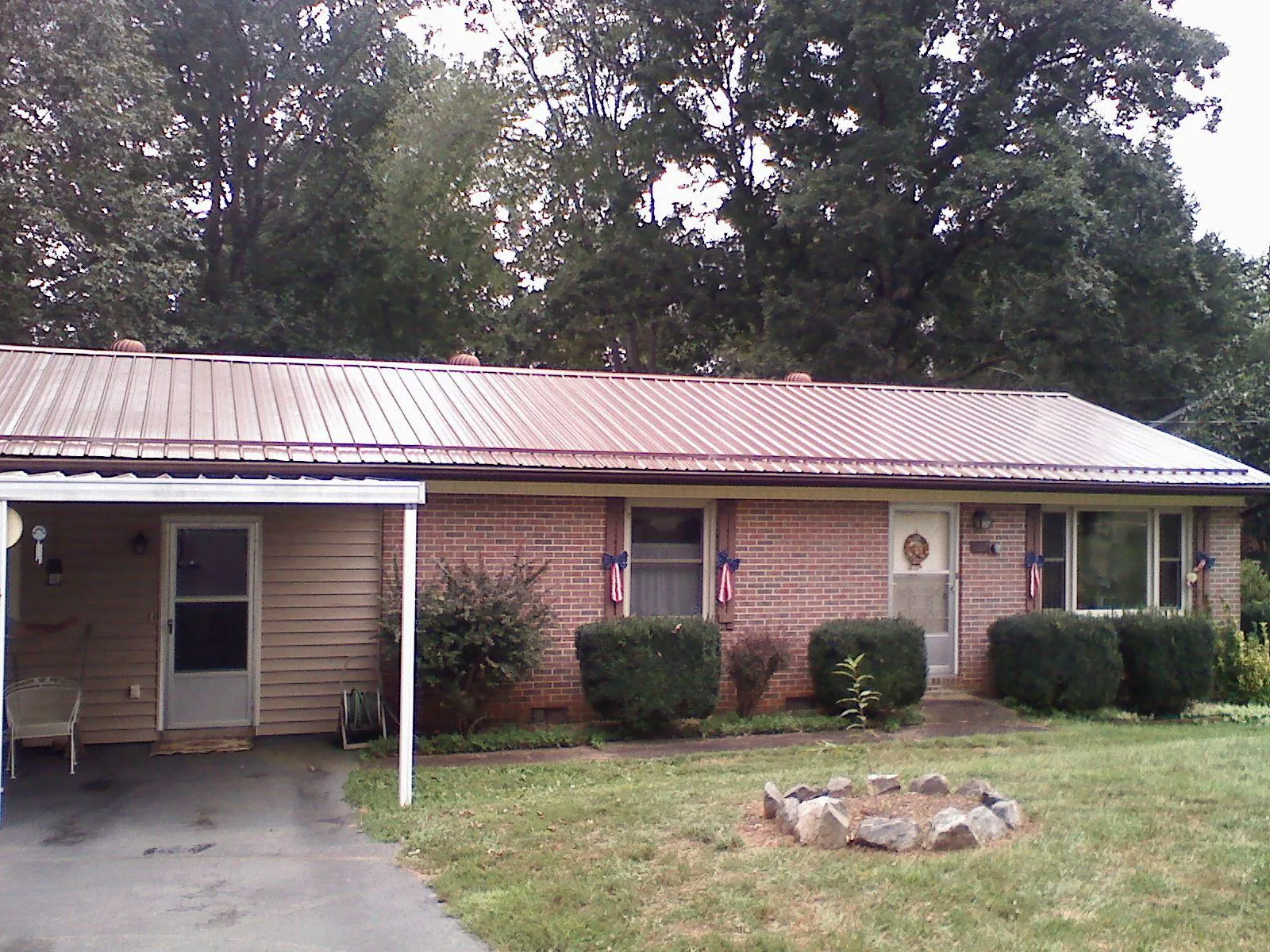 Bronze metal roof and carport on a brick ranch home — Roof Repair work by our crew in Corral